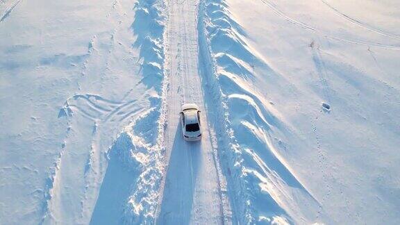 跟在一辆白色轿车后面那辆车正行驶在雪地上
