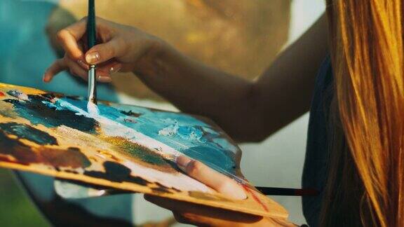 妇女在木制调色板上手工调色油画创意艺术家绘画图片