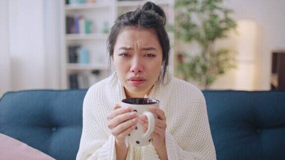 患有感冒或流感流鼻涕的抑郁亚洲妇女喝热茶