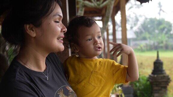 一个亚洲女人和她的儿子坐在院子里