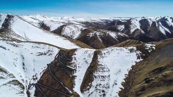 连绵的雪山下是一条蜿蜒的山路