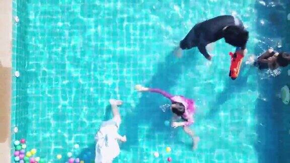 夏季亚洲家庭在一个岛上的豪华海滨度假泳池里玩耍
