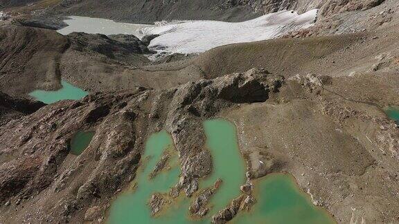 绿色冰川湖和常年冰川在CimaFontana伯尔尼纳山脉在夏季在意大利Valmalenco空中前倾显示