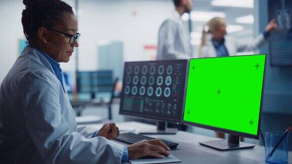 医院研究实验室:黑人女性医学生物技术科学家工作在绿屏色度键计算机与脑扫描MRI图像背景:神经科学家开会分析核磁共振扫描