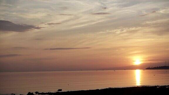 清晨印尼巴厘岛热带海滩上的日出