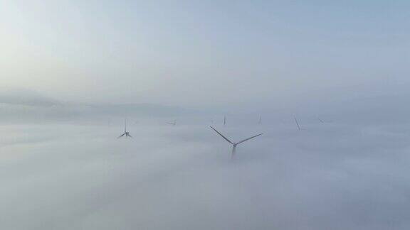 在晨雾中的风力涡轮机农场的实时鸟瞰图