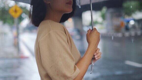 女人在雨中撑伞的慢动作