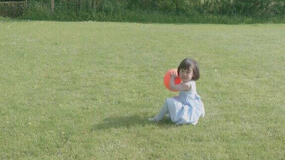 初学走路的小女孩在夏天乡下的家花园里玩耍