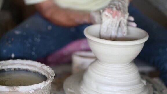 亚洲华人活跃的男子波特在他的工作室与纺织陶瓷轮工作