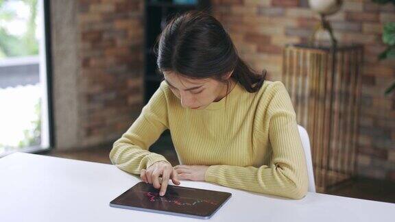 年轻女子在家里使用数字平板电脑