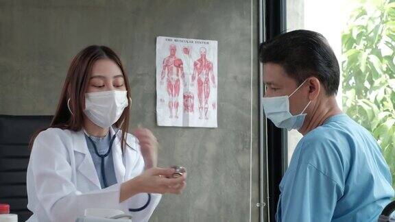 一位亚洲女医生正在为一位老年残疾人检查身体