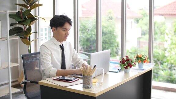 专注的商人在办公室桌上用笔记本电脑工作