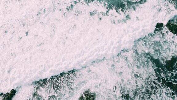 海浪撞击岩石海岸线的抽象鸟瞰图