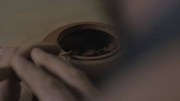 一位工匠用一把木刀将宜兴陶土做成茶壶倒角茶道用手工陶壶褐色陶器茶壶4k的视频23.98帧秒