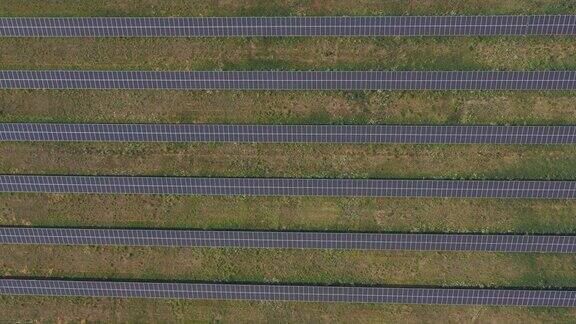 太阳能电池板发电的鸟瞰图一排排的太阳能电池板安装在农田、草地或农村地区生态和可再生绿色能源前拍摄