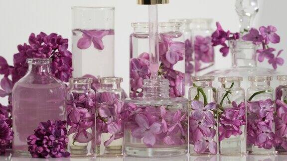 丁香精油带有紫丁香香味的花香香水香水在实验室生产香水一滴精油从化妆品吸管中缓缓滴入香水中