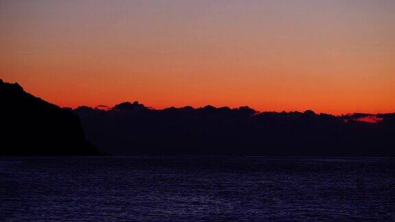 太阳落山后海面上的红橙色天空时间流逝