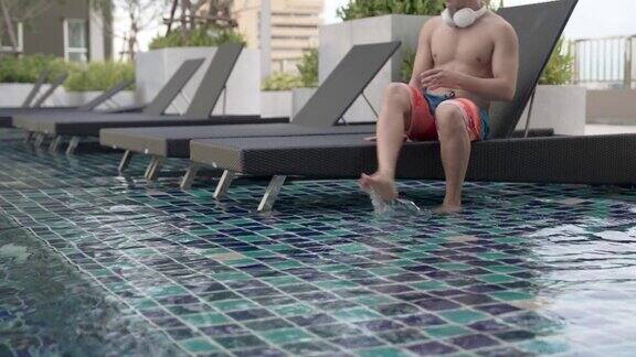 亚洲男人正在私人泳池别墅里享受假期