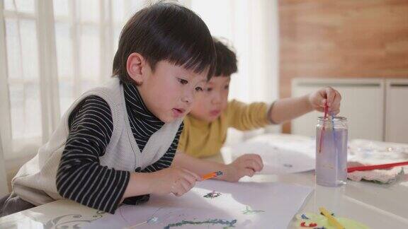 两个小男孩在窗前画画