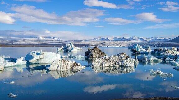 4k时间移动的云与蓝色冰山漂浮在Jokulsarlon冰湖冰岛