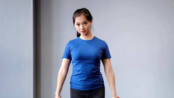自信的年轻亚洲健身女性做锻炼使用哑铃享受训练