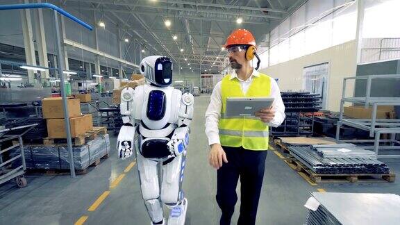 人类工厂工人和机器人一起在工厂里行走