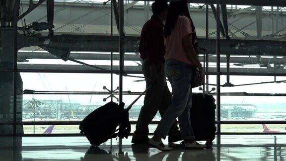 幸福亚洲老年夫妇的剪影一起在机场候机楼等待离开老年人的旅程老情人旅行飞行退休了假期