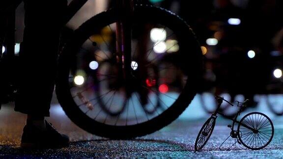 很多骑自行车的人在晚上骑自行车在模糊的自行车游行在灯光照亮城市街道的背景下自行车timalapse的小比例模型一群骑自行车的人自行车交通概念运动健康的生活方式明亮的强光照射低