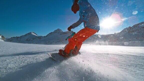 SLOMOTS滑雪板在一个阳光明媚的日子里在一个朋友后面滑下雪道