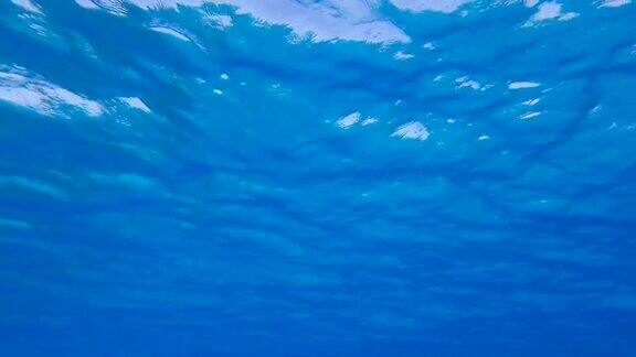 慢镜头蓝色的水面自然背景与阳光在蓝色的水面上闪烁蓝色海水表面反射阳光的纹理水下拍摄