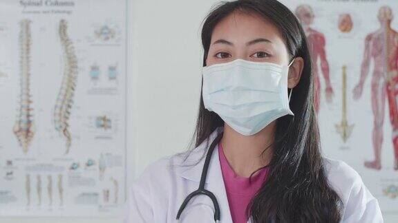 年轻的亚洲女医生戴着防护面罩和微笑