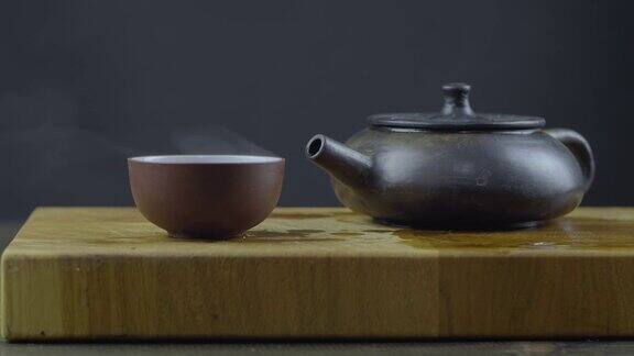 手工制作的宜兴砂茶壶用木板上的碗盛热茶4k的视频59.94帧秒
