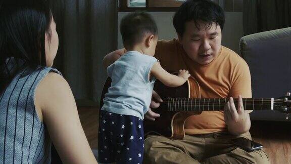 男人和他的儿子在弹吉他