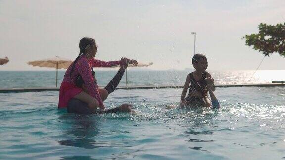 快乐亚洲家庭一起玩进游泳池家庭假期和旅游