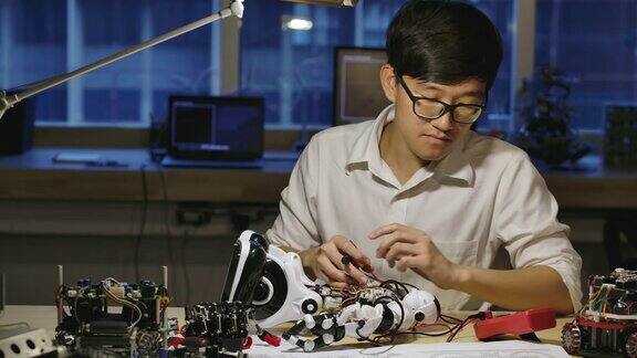 年轻的亚洲电子开发工程师晚上在计算机科学研究实验室里建造、测试、修理机器人有技术或创新观念的人