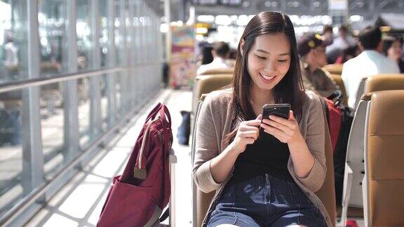 年轻女子在等飞机的时候玩智能手机慢镜头