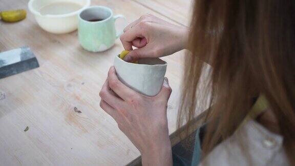 陶器匠用未加工的粘土制作杯子制造陶瓷手工陶器店