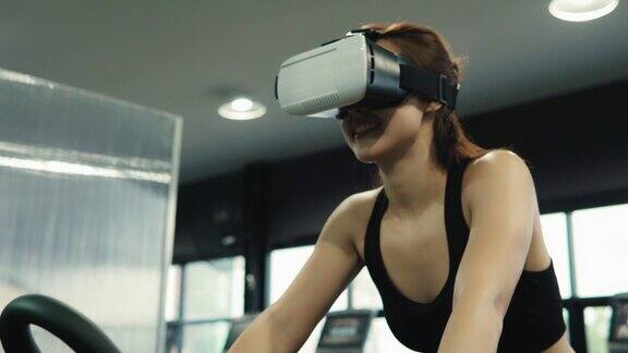 年轻女性喜欢做健身使用虚拟现实的虚拟跑步在健身房锻炼