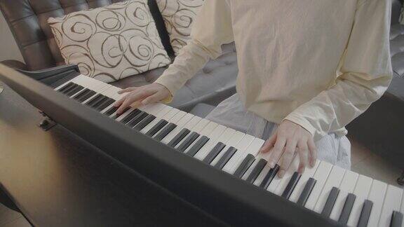特写亚洲少年在家里的客厅里弹奏键盘钢琴美丽的女孩钢琴家在社交媒体上直播弹钢琴网络影响者Vlog或网络教学