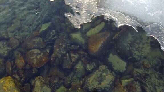 在春天的时候沿着阿尔泰河的卡顿的一块浮冰的窗状边缘移动的特写视频