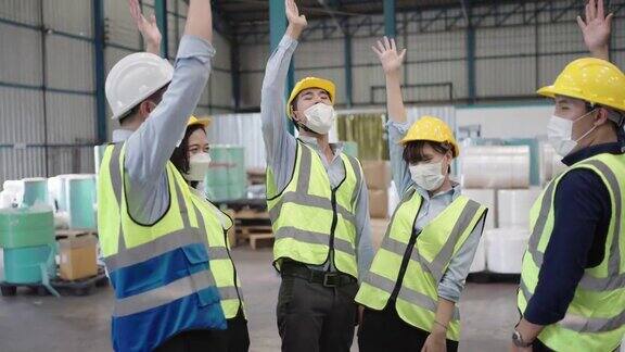 一群亚洲工人在工厂里手拉手
