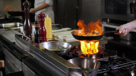 餐厅厨房里的红酒酱在平底锅里燃烧的特写镜头