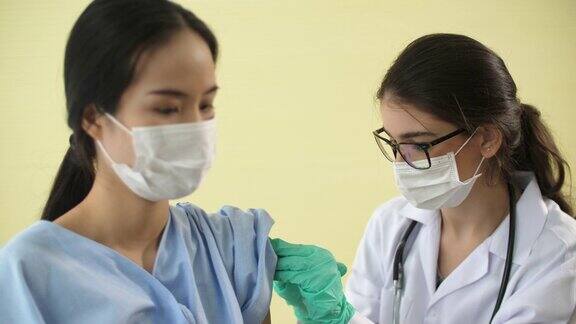 医生给妇女注射新冠病毒疫苗