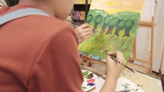 美术教室里老师教一个小女孩学习亚克力彩绘
