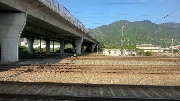 从一列行驶的火车上拍摄经过一个铁路立交和高架桥的底部