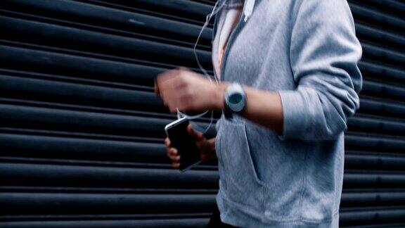 手持智能手机的跑步者和听音乐的慢动作