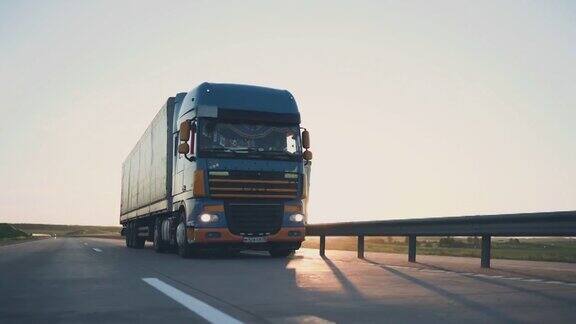 带货运拖车的半卡车在日落时行驶