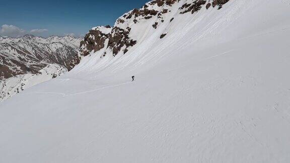 空中全景观看运动员滑雪攀登雪山山顶阳光高山冬季景观