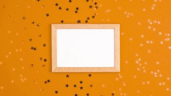 定格动画模型的白色框架和星星周围充满活力的橙色背景母亲节节日礼物快乐的生日概念与空间为您的文本模板平铺