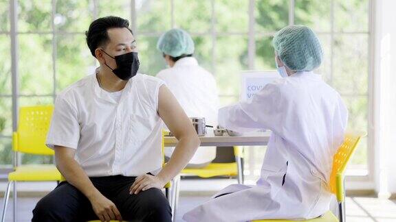 医生或护士正在病房为男性患者接种COVID-19或流感疫苗